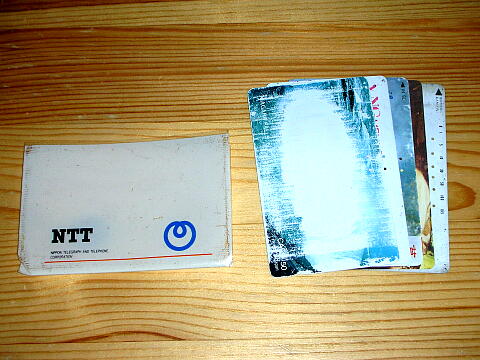 手持ちのテレカと破けたビニールケースの写真